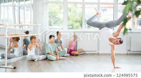 Male dancer performing pirouette in front of class 124995575