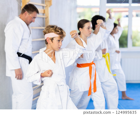 Group of children train karate techniques 124995635