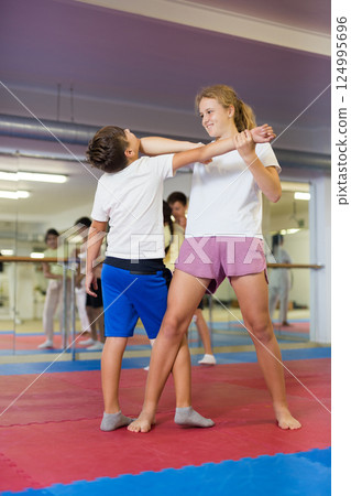 Kids learning self-defence moves in gym 124995696