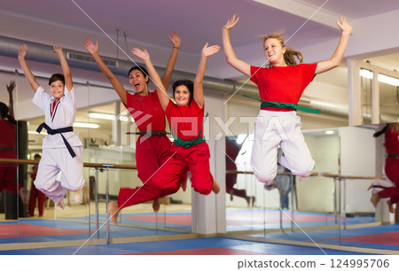 Kids and karate trainer jumping in gym 124995706