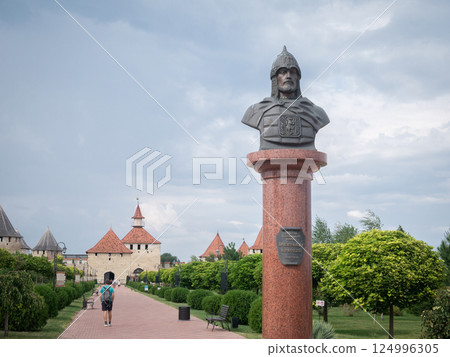 Historical statue of medieval warlord with historical fortress in backdrop, Moldova, Europe Historical statue of medieval warlord with historical fortress in backdrop, Moldova, Europe 124996305