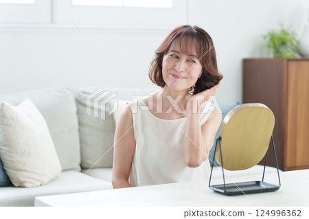 Senior woman doing hair care (hair/beauty) 124996362