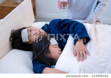 Parents and children being cared for in bed 124996484