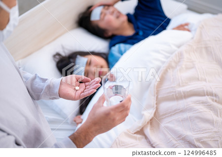 Parents and children being cared for in bed 124996485