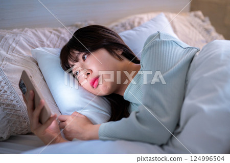 A woman who watches the smartphone after late at night 124996504