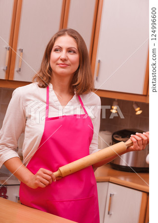 Housewife with rolling pin in kitchen Housewife with rolling pin in kitchen 124996600