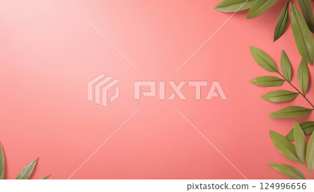 Tropical leaves arranged on coral pink background create vibrant and fresh atmosphere, perfect for nature themed designs or backgrounds 124996656