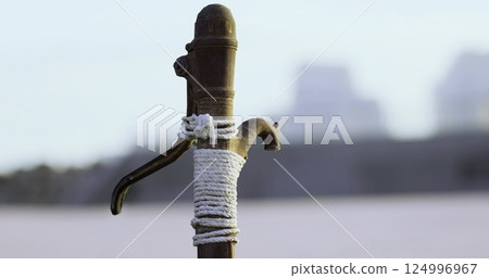 Old wooden post secured with rope at riverbank during calm evening Old wooden post secured with rope at riverbank during calm evening 124996967