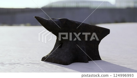 Blacksmiths anvil resting on a white surface under bright sunlight Blacksmiths anvil resting on a white surface under bright sunlight 124996993