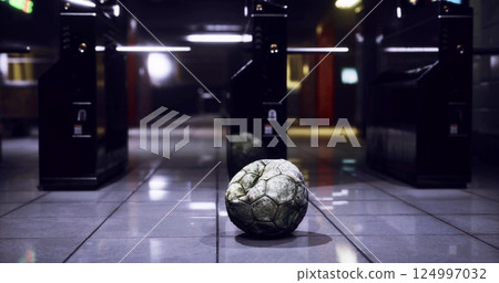 Soccer ball on polished floor by ticket gates in a station Soccer ball on polished floor by ticket gates in a station 124997032