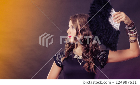 beautiful brunette woman with black fan in hand beautiful brunette woman with black fan in hand 124997611