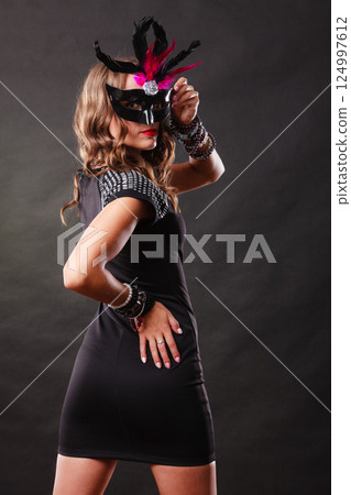 Woman with carnival venetian mask on dark Woman with carnival venetian mask on dark 124997612