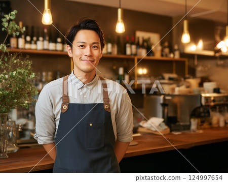 A smiling male clerk at a warm cafe 124997654