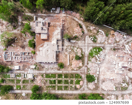 Aerial drone view of old demolished industrial building. Pile of concrete and brick rubbish, debris, rubble and waste of destruction ruins of abandoned factory or plant. Earthquake city landscape 124997699