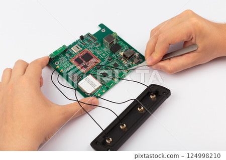 Hands of a master holding an electronic board on a Hands of a master holding an electronic board on a 124998210