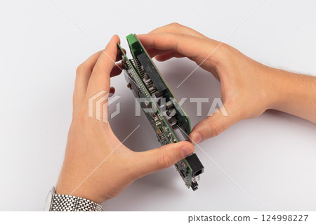 Hands of a master holding an electronic board on a Hands of a master holding an electronic board on a 124998227