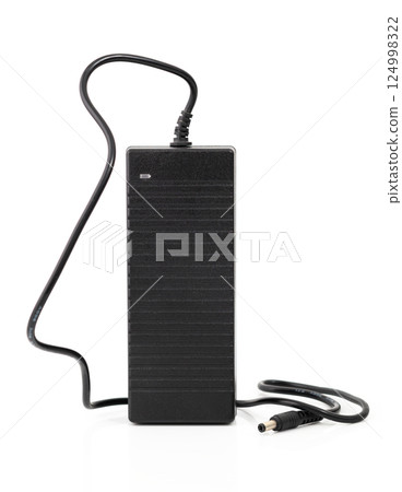 Black power adapter with cable and connector, isolated on white background. Essential accessory for charging devices. 124998322