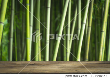 Bamboo forest table. Empty wooden table for product display on green bamboo forest background 124998345