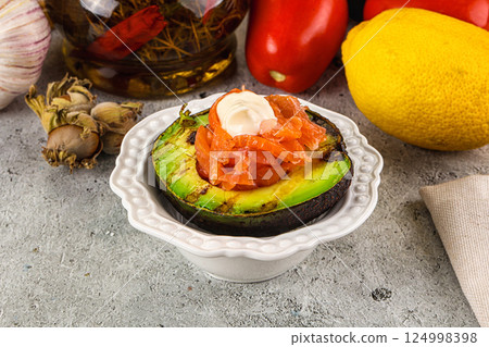 Whole grilled avocado with salmon 124998398