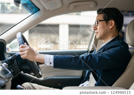 A man driving a car 124998515