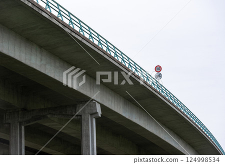 Highway bridge with speed limit sign, low-angle view, in Stuttgart, Germany. 124998534