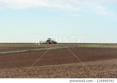 Tractor plowing agricultural fields outside of Stuttgart city, Germany 124998542