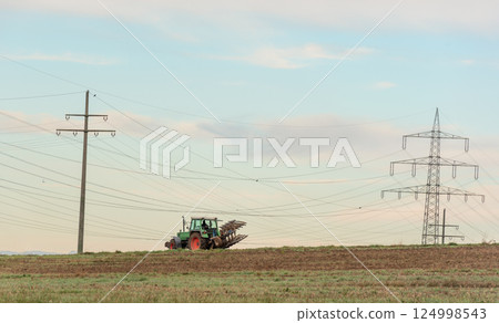 Tractor working the agricultural fields outside of Stuttgart city, Germany 124998543