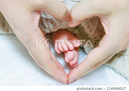 Newborn's foot and mama's hand Newborn's foot and mama's hand 124999027