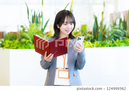 Business woman operating a smartphone Business woman operating a smartphone 124999362