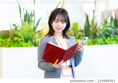 Business woman operating a smartphone Business woman operating a smartphone 124999363