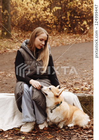 Woman with Corgi in Autumn Park Woman with Corgi in Autumn Park 124999447