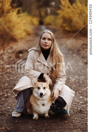 Woman with Corgi in Autumn Park Woman with Corgi in Autumn Park 124999450
