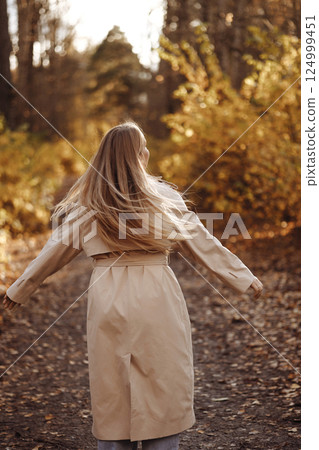 Woman Twirling in Autumn Forest Path. Rear View 124999451
