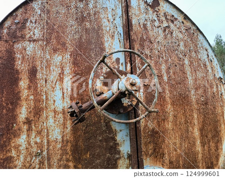 A rusty water or liquid tank abandoned in the middle of the forest. The problem of ecology 124999601