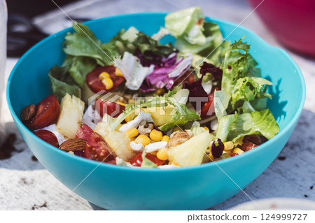 This colorful salad features fresh greens, tomatoes, corn, nuts, and pineapple. This colorful salad features fresh greens, tomatoes, corn, nuts, and pineapple. 124999727