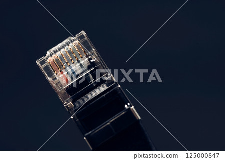 Close-up of a network cable connector highlighting its gold contacts, symbolizing internet connectivity and data transfer 125000847