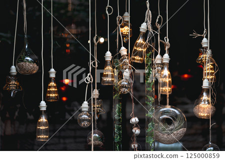 Hanging light bulbs and terrariums creating a cozy ambiance 125000859