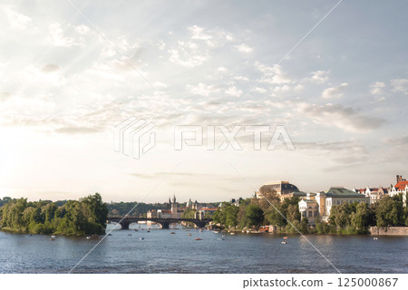 The Vltava river flowing through Prague on a summer day with boats and clouds 125000867