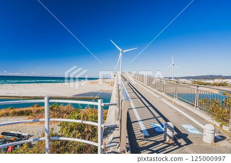 Kuniyasu Coast, Shiosai Bridge, and wind power generation facilities in Kakegawa City, Shizuoka Prefecture, against the blue sky Kuniyasu Coast, Shiosai Bridge, and wind power generation facilities in Kakegawa City, Shizuoka Prefecture, against the blue sky 125000997