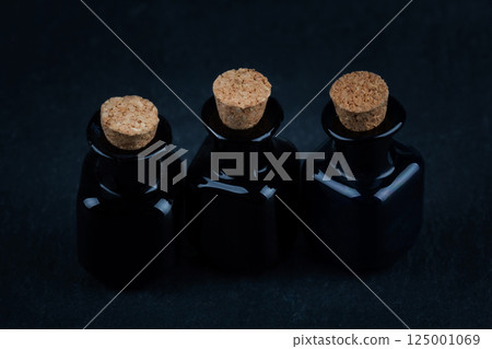 apothecary black glass bottles on black 125001069