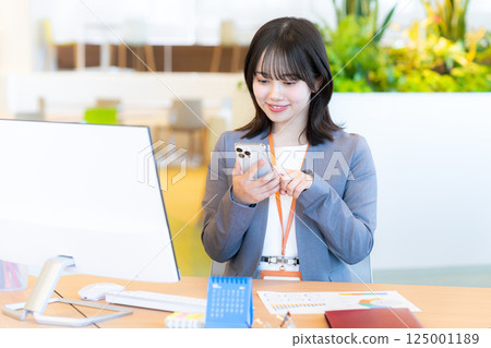 Business woman with a smartphone in the office 125001189