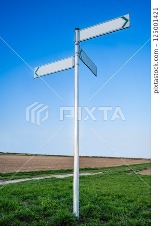 white road sign with three plates indicating directions in different directions white road sign with three plates indicating directions in different directions 125001421