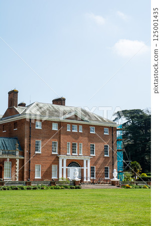 An old red brick building under bright sunlight in Hatchlands Park, a suburb of London 125001435