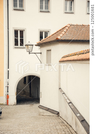 A picturesque European alley with historic buildings, a vintage street lamp, and a traditional A picturesque European alley with historic buildings, a vintage street lamp, and a traditional 125001681