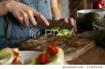 Little Girl Cutting Avocado For Healthy Breakfast Little Girl Cutting Avocado For Healthy Breakfast 125001930