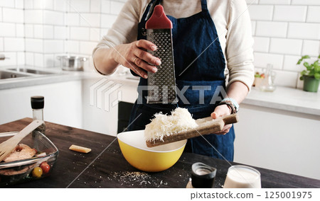 Girl Chef Grating Hard Parmesan Cheese 125001975
