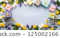 Colorful gift boxes with fresh flowers creating a festive arrangement on a light background with copy space 125002166