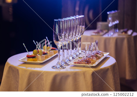 Appetizer Plate. An area for welcoming guests with food and empty champagne glasses 125002212
