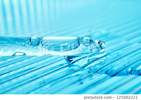 Serum in a pipette on a blue ribbed background. Serum in a pipette on a blue ribbed background. 125002221