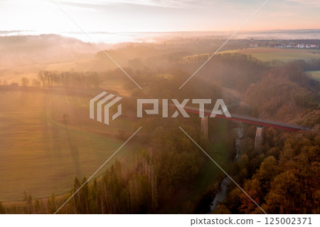 Drone aerial view of a railway bridge crossing the river in nature at sunrise on a winter morning Drone aerial view of a railway bridge crossing the river in nature at sunrise on a winter morning 125002371